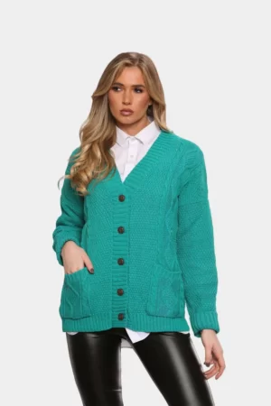 A beautiful blond hair woman wearing chunky cable knitted button cardigan for women in jade green color against solid grey background