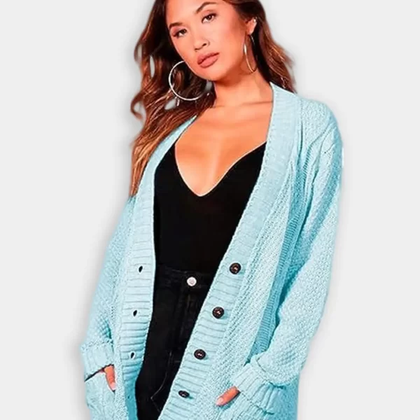 Beautiful woman wearing chunky aran cable knitted granted button cardigan against grey background